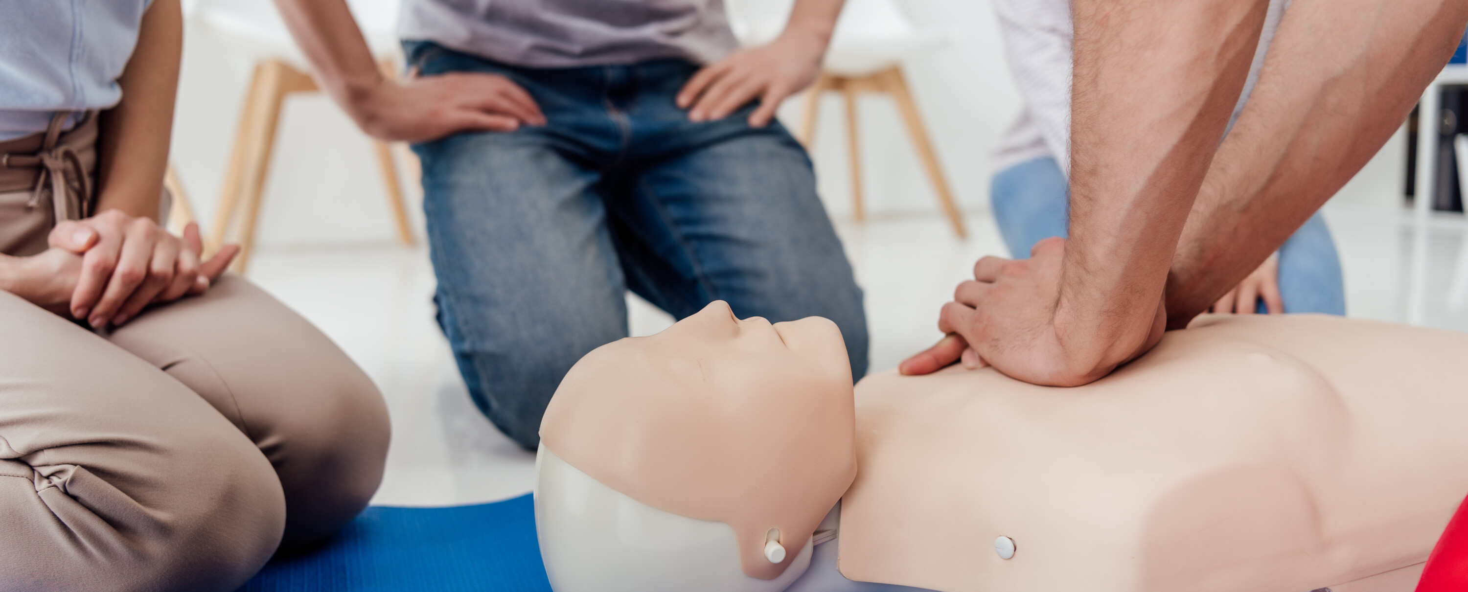 cropped view of man performing chest compression on dummy during